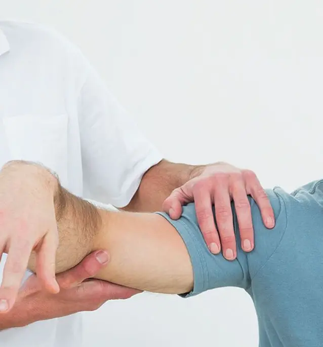 Physical therapy session showing therapist working on patient's shoulder