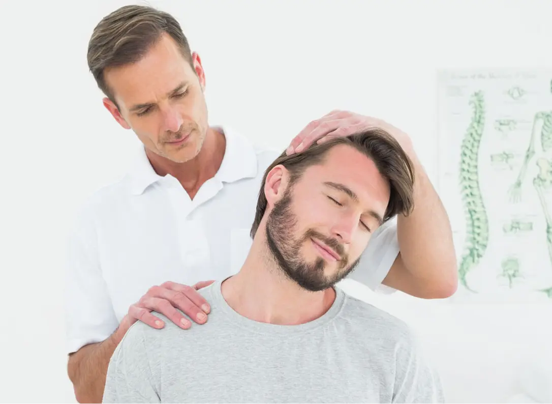 A therapist treating a man's neck pain